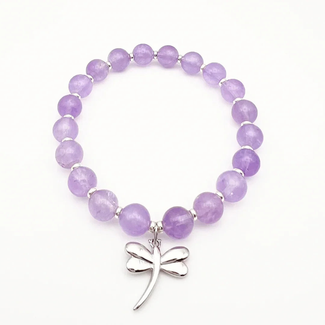 Amethyst crystal bracelet with a sterling silver dragonfly charm on a white background
