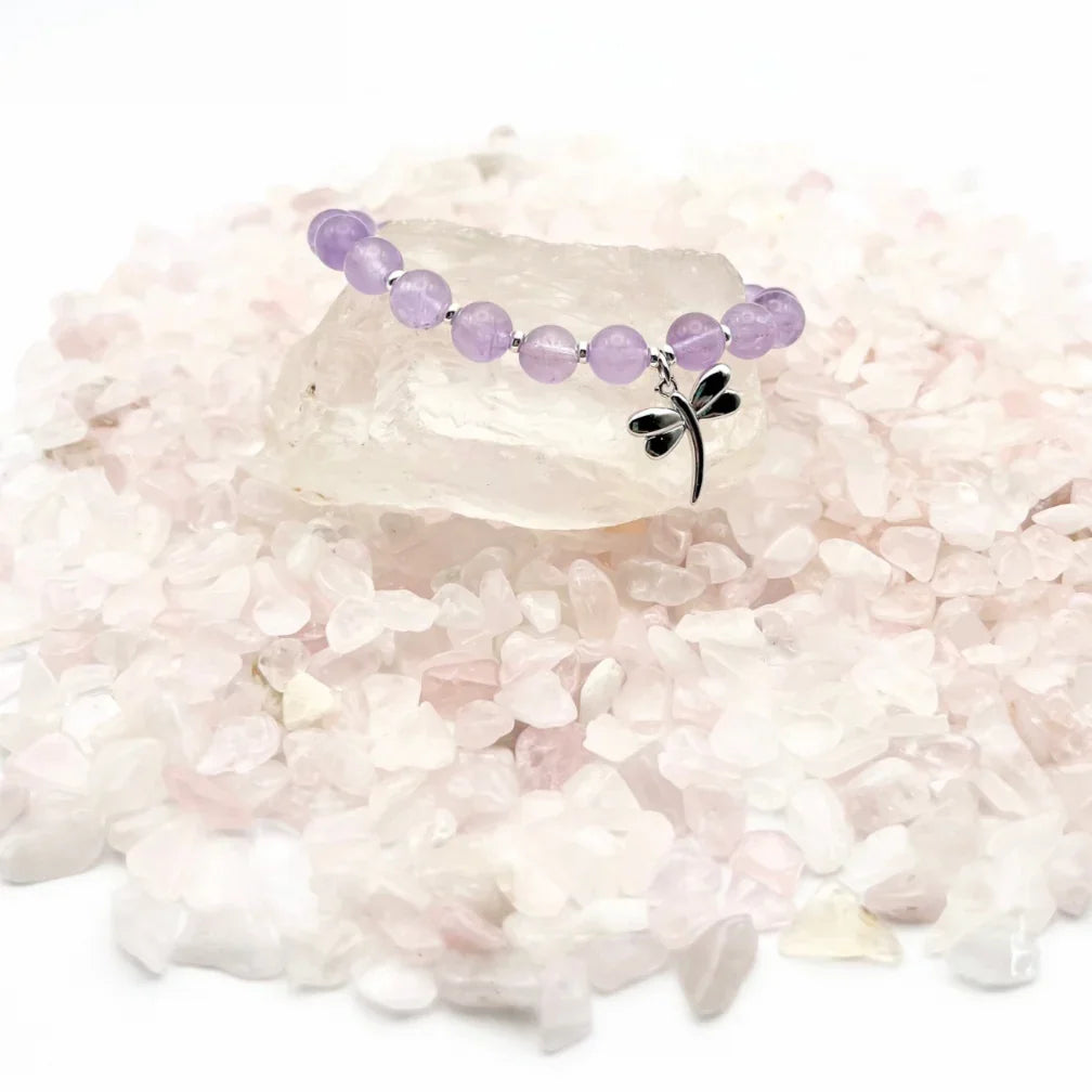 Amethyst crystal bracelet with a sterling silver dragonfly charm on a bed of crystals