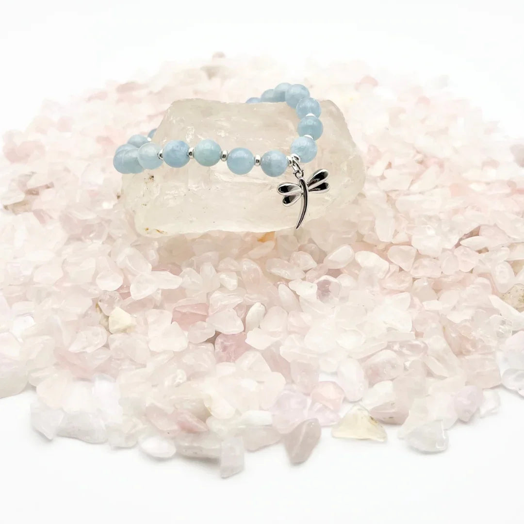 Aquamarine crystal bracelet with a sterling silver dragonfly charm on a bed of crystals