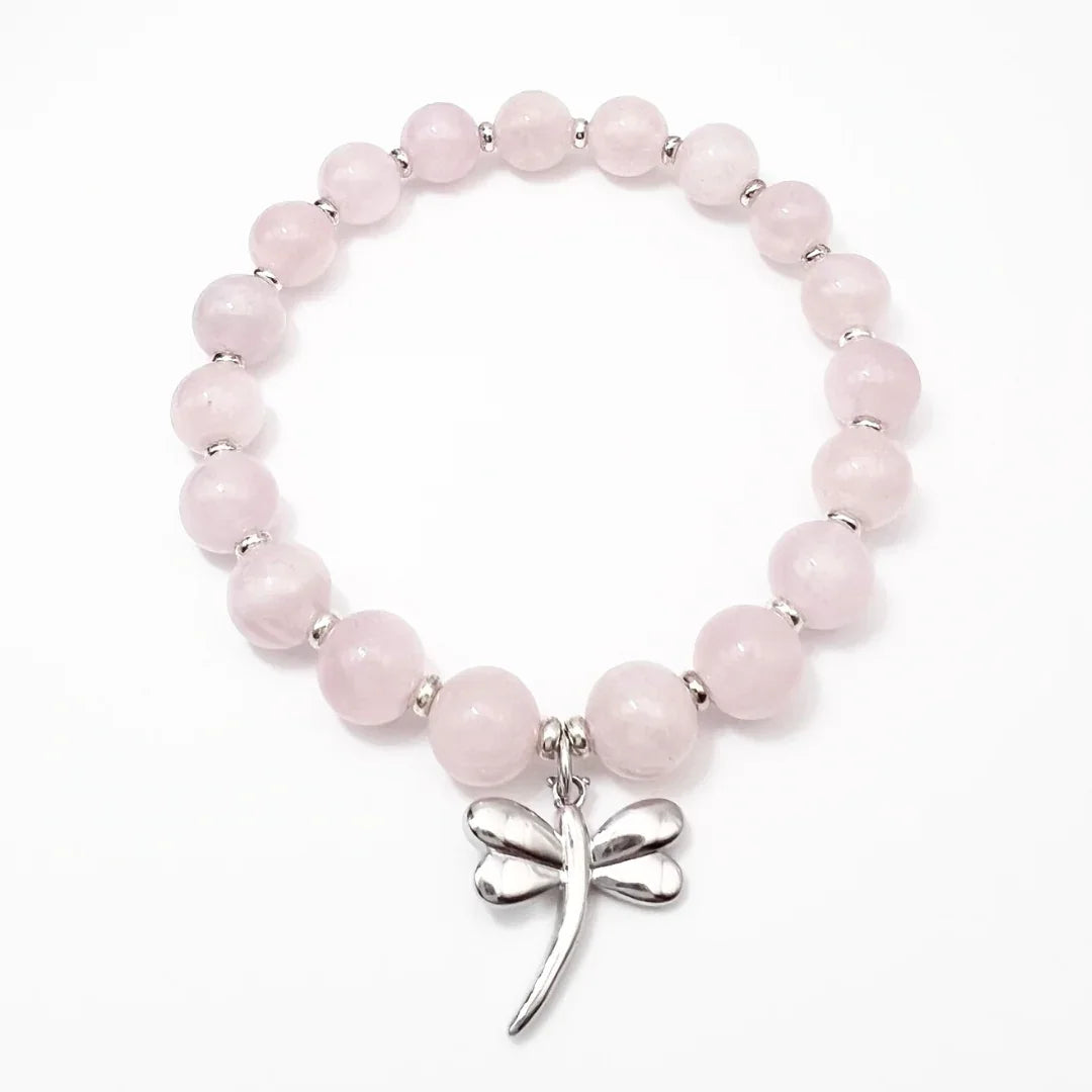 Rose Quartz crystal bracelet with a sterling silver dragonfly charm on a white background