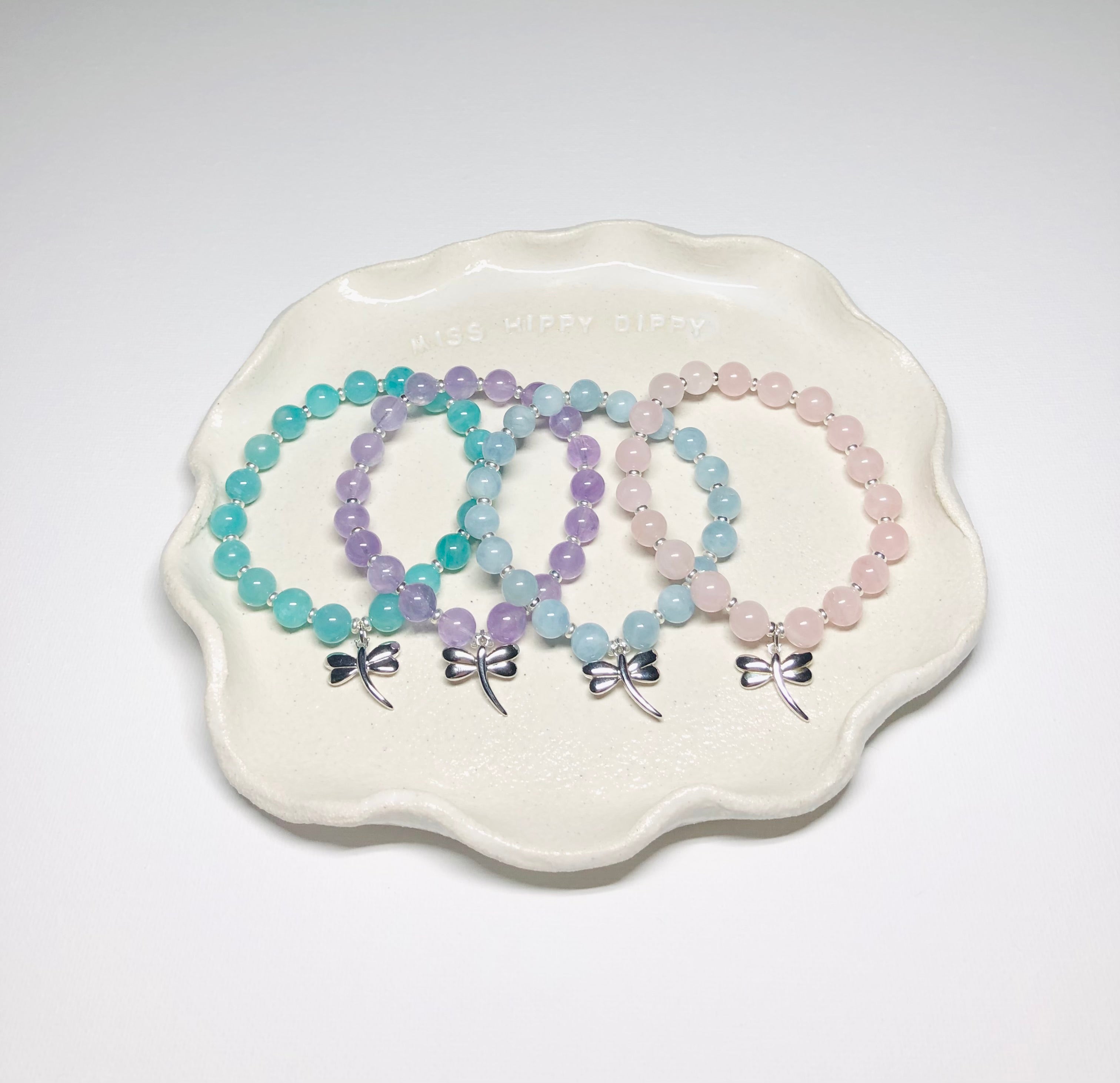 The four crystal bracelets from The Pastel Collection sitting on a clay plate